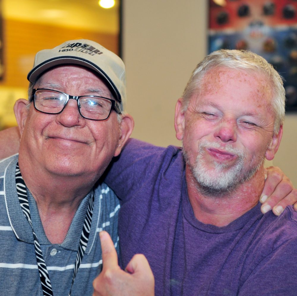 Transportation – 2 older men 2 older men grinning with arms around each others shoulders