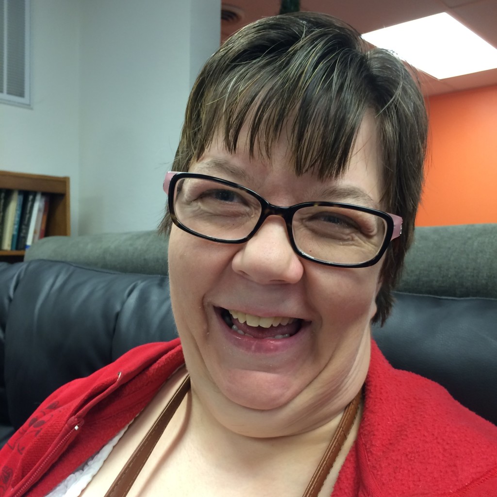 Woman in a red shirt and wearing glasses smiling