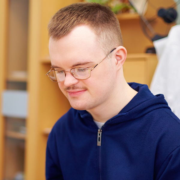 Man in glasses looking down working