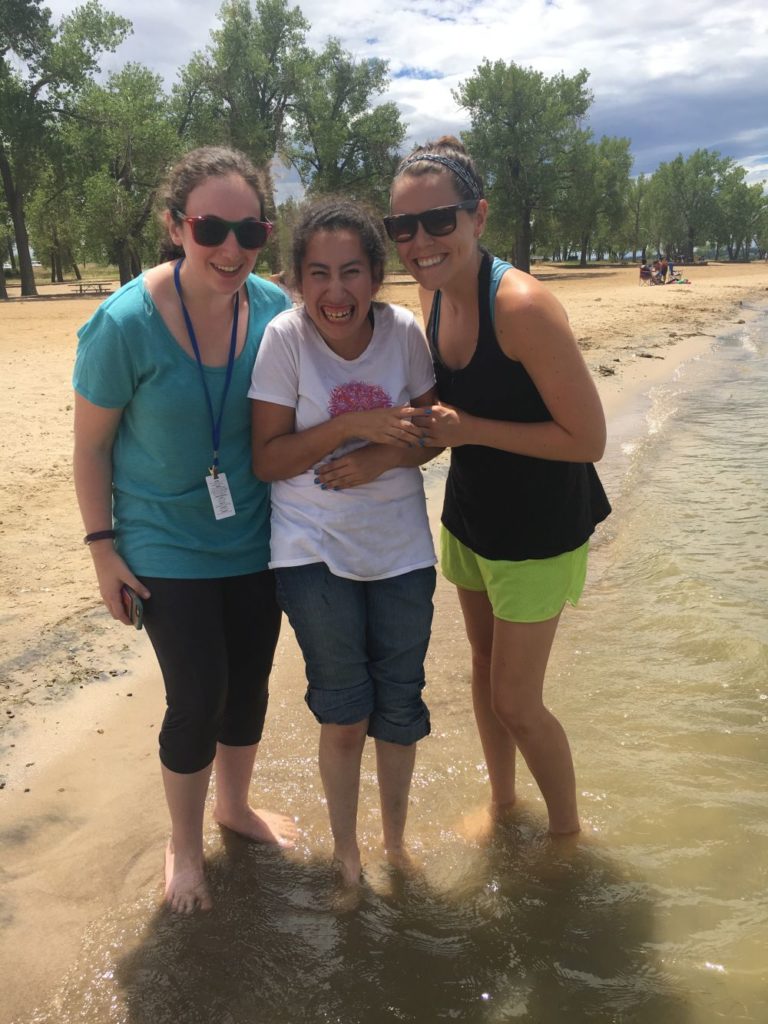 Happy girl with 2 happy Continuum of Colorado providers standing in the sand
