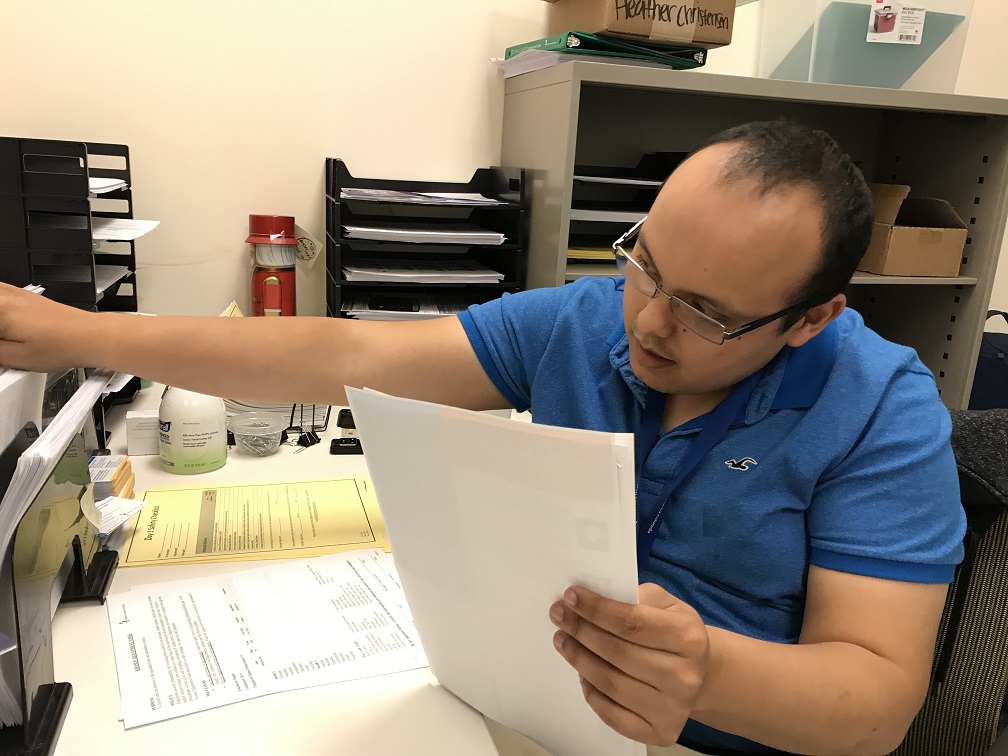 Man in blue shirt working at a desk