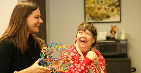 CoC Staff Member with woman smiling in a red sweater